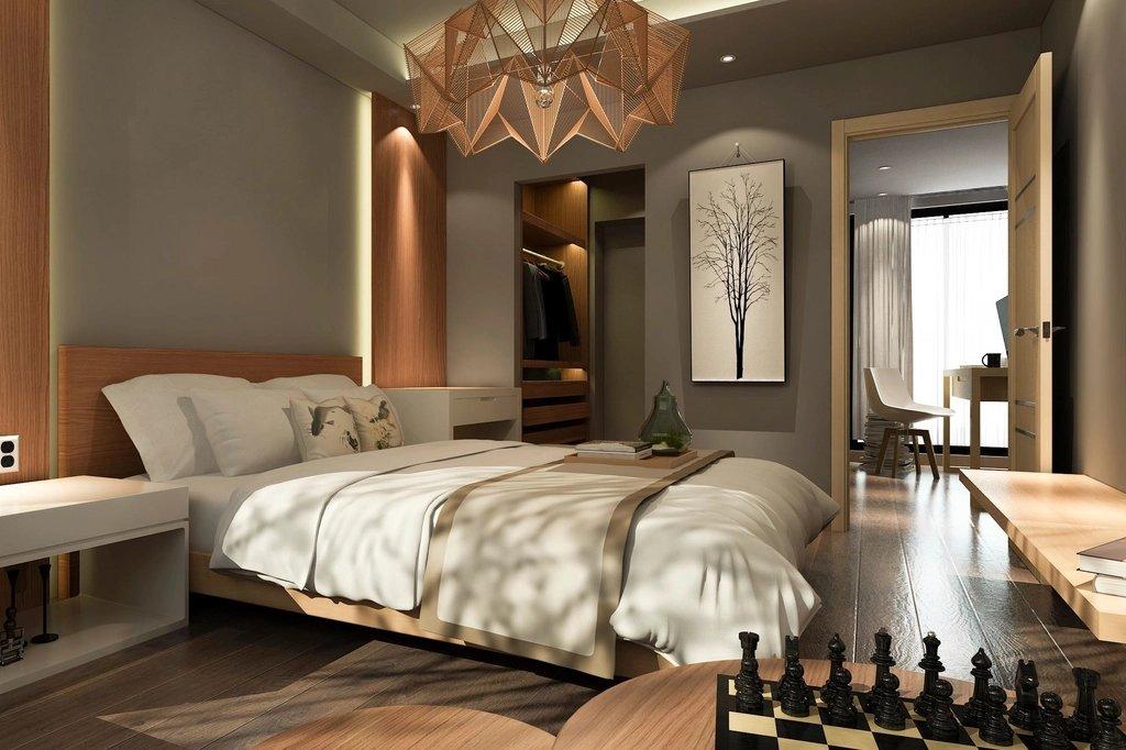 A bedroom with a made bed and warm lighting